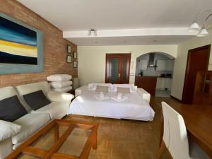 Un dormitorio con una cama blanca y una sala de estar. en KAIOA .Incluye parking privado., en Hondarribia