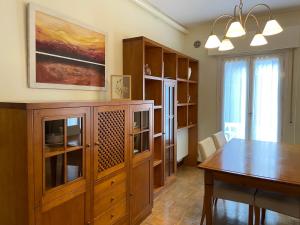 a dining room with a table and a wooden cabinet at KAIOA .Incluye parking privado. in Hondarribia