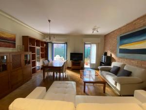 a living room with white furniture and a brick wall at KAIOA .Incluye parking privado. in Hondarribia