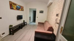 a living room with a couch and a brick wall at Appartamento Magenta 5 in Turin