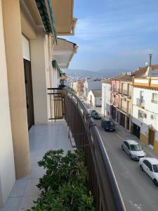 a balcony of a building with cars parked on a street at Apartamento Al Andalus in Baena