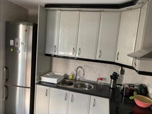 a kitchen with white cabinets and a stainless steel refrigerator at Apartamento Al Andalus in Baena