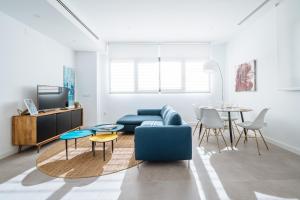 a living room with a blue couch and a table at Apartmentos Marqués de Nervion in Seville