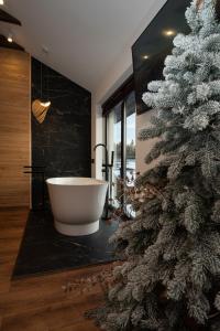 a bathroom with a christmas tree and a bath tub at Chillax Chalet in Yablunytsya