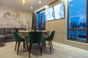 a dining room with a table and chairs and a couch at Chillax Chalet in Yablunytsya