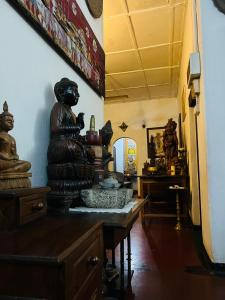 Cette chambre dispose d'une table avec une statue. dans l'établissement Traditional Kandyan House, à Kandy