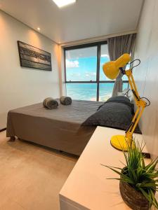 a bedroom with a bed with a view of the ocean at Paiva (Barra Home Stay) Luxuoso - vista incrível 26 andar in Recife