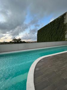 een zwembad met een hek en blauw water bij Paiva (Barra Home Stay) Luxuoso - vista incrível 26 andar in Recife