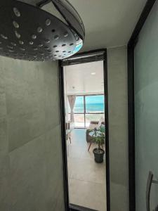 eine Glastür zu einem Zimmer mit Meerblick in der Unterkunft Paiva (Barra Home Stay) Luxuoso - vista incrível 26 andar in Recife