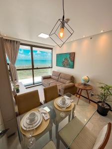 a living room with a couch and a table with chairs at Paiva (Barra Home Stay) Luxuoso - vista incrível 26 andar in Recife