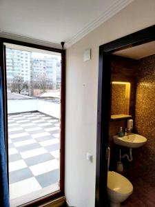 a bathroom with a toilet and a sink and a window at Byzanthin Hostel in Bucharest