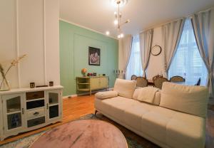 een woonkamer met een witte bank en een aantal ramen bij Mint 13 @ Mariahilf in Wenen