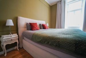 - une chambre avec un lit doté d'oreillers rouges et une fenêtre dans l'établissement Mint 13 @ Mariahilf, à Vienne