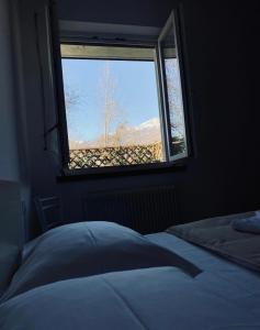 a bedroom with a window with a view of a mountain at La Rocchetta, Borgo Valsugana in Borgo