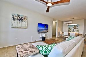 a living room with a white couch and a ceiling fan at Ocean & Marina Views 3 Bedroom 2 Bathroom Luxury Condo in Fajardo