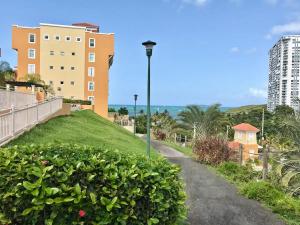 une passerelle menant à un bâtiment avec une colline dans l'établissement Ocean & Marina Views 3 Bedroom 2 Bathroom Luxury Condo, à Fajardo