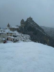 a snow covered hill with houses and a mountain at Casa Corralazos in Castril