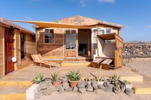 a house in the desert with a tv on a patio at Alaia Tiny House between volcanoes and beach breaks in El Cotillo