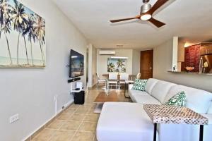 a living room with a white couch and a ceiling fan at Ocean & Marina Views 3 Bedroom 2 Bathroom Luxury Condo in Fajardo