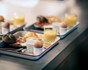 un buffet con platos de comida, huevos y pan en YUST Liege, en Lieja