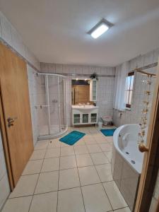 a bathroom with a shower and a tub and a sink at Piece of Greece in Neunburg vorm Wald