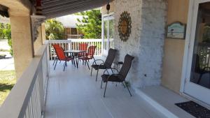 un patio con sillas y una mesa en un porche en Spacious Beach House Unit,Beautifully Furnished 2 Bed 2Bath./2Min.Walk To Beach en Clearwater Beach