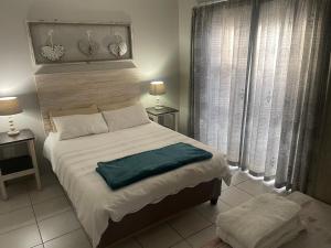ein Schlafzimmer mit einem großen Bett und zwei Fenstern in der Unterkunft Anas Inn in Walvis Bay + 30 Fotos