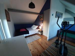 een kleine slaapkamer met een bed en een camera bij Maison Chaleureuse Bord de Mer in Primelin