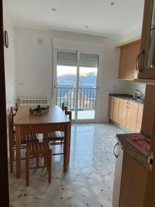 eine Küche mit einem Tisch und Stühlen mit Aussicht in der Unterkunft Casa turismo rural Becar in Corullón + 13 Fotos