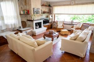 sala de estar con sofás blancos y chimenea en Villa Patrizia con piscina privata, en Stintino