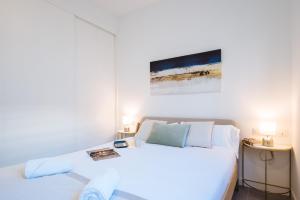 1 dormitorio con 1 cama blanca y 2 mesas en Apartmentos Marqués de Nervion, en Sevilla