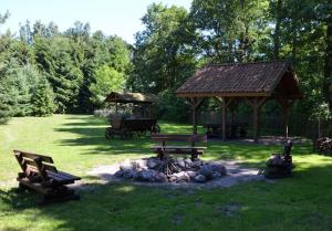 a park with benches and a fire pit with a gazebo at Farma Jantar in Jantar