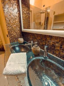 W łazience znajduje się umywalka i lustro. w obiekcie il Sole di Baggio w Mediolanie