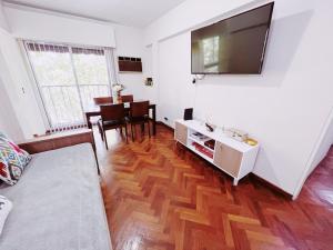 sala de estar con TV grande y mesa en Departamento Peatonal Sarmiento en Mendoza