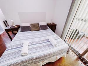 ein Schlafzimmer mit einem großen Bett mit weißer Bettwäsche und Kissen in der Unterkunft Departamento Peatonal Sarmiento in Mendoza