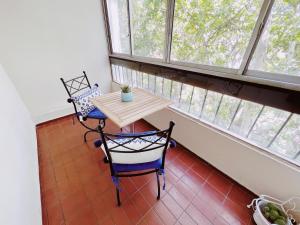 einen Tisch und Stühle in einem Zimmer mit Fenstern in der Unterkunft Departamento Peatonal Sarmiento in Mendoza
