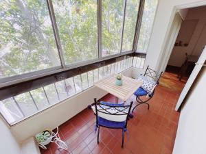 balcón con mesa y sillas frente a las ventanas en Departamento Peatonal Sarmiento en Mendoza