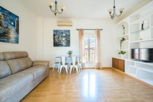 un soggiorno con divano e tavolo di Distinguido y céntrico apartamento en San Bernardo a Siviglia