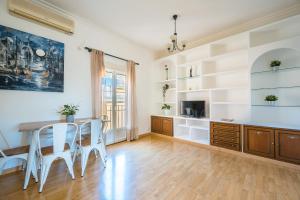 un soggiorno con tavolo, sedie e TV di Distinguido y céntrico apartamento en San Bernardo a Siviglia