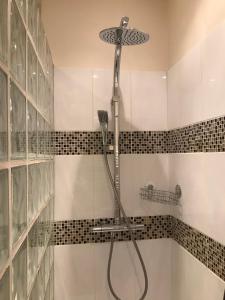 y baño con ducha y azulejos blancos y negros. en Magnifique 2 pièces de 65m2 -quartier des Musiciens en Niza
