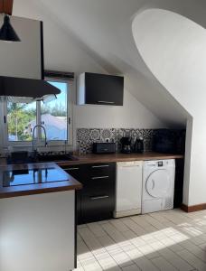 a kitchen with a sink and a washing machine at Duplex Côté Mer in Filaos