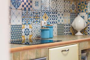 een keuken met blauwe en witte tegels op de muur bij Casa vacanza - Le Mennule in Alliste +22 foto's