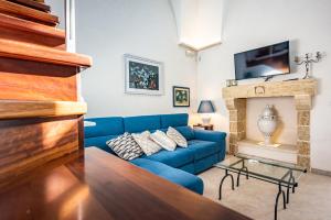 een blauwe bank in een woonkamer met een open haard bij Casa vacanza - Le Mennule in Alliste