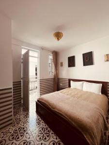 um quarto com uma cama e uma porta para uma varanda em Riad Allal em Marrakech