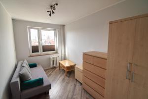 a living room with a couch and a dresser at Beautiful view in Gdańsk