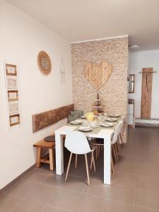 een eetkamer met een witte tafel en een bakstenen muur bij NewHome Nicole Premantura in Premantura