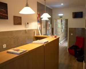 an office with a reception desk and a red chair at HOSPEDARIA LONDRES in Porto