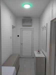 Apartman Aleksić u centru grada في Knjazevac.: غرفة بيضاء مع باب مع مقاعد وطاولة