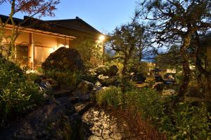 una casa con un patio con rocas y árboles en Oni no Sumika en Izu