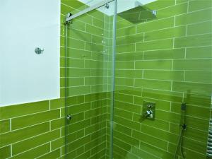 eine grün geflieste Dusche mit Glastür in der Unterkunft Napoletando b&b in Neapel